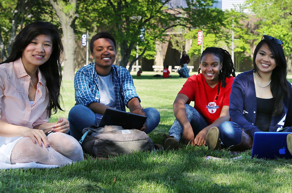 Students sitting together in the grass on a sunny day