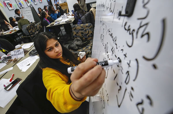 Woman student writing a mathematical equation